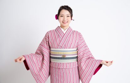 ピンク系の縞柄の着物を着ている女性の画像