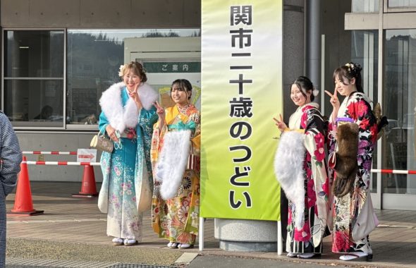 一関市二十歳のつどい会場玄関前で記念撮影する振袖姿の女性4人