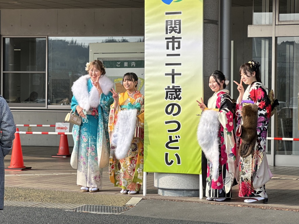 一関市二十歳のつどい会場玄関前で記念撮影する振袖姿の女性4人