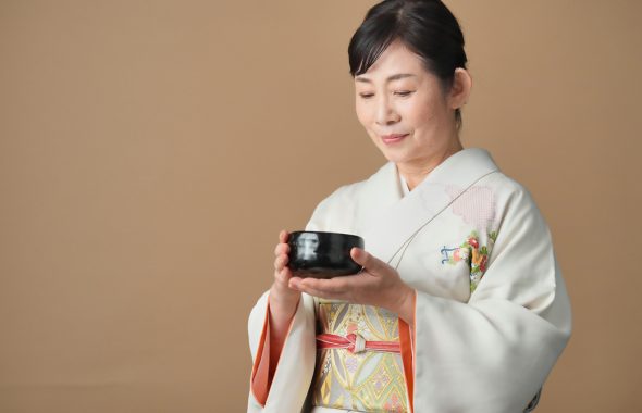 着物を着た女性が茶道をする様子の写真