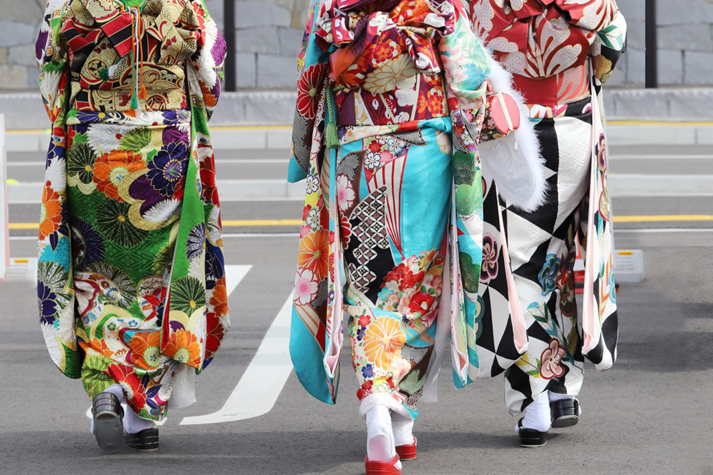 二十歳の集いに振袖を着て街を歩く3人の女性のイメージ画像