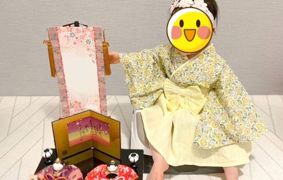 着付け講師のお孫さんの初節句での記念写真 黄色の着物と袴でお雛様と一緒に撮影