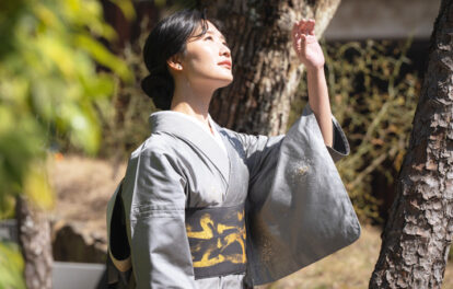 眩しい日差しを避ける様子の着物姿の女性の画像