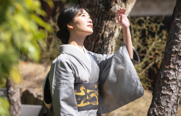 眩しい日差しを避ける様子の着物姿の女性の画像