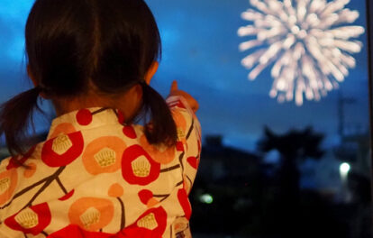 浴衣姿で花火を見学する子どもの画像