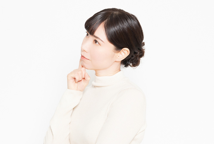 悩んでいる様子の女性の画像