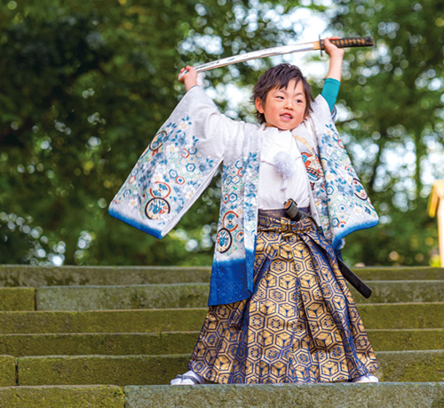 七五三で袴を着た男の子が刀でポーズをとる画像